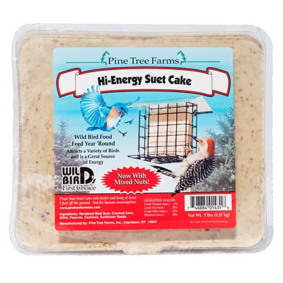 Large 3-pound suet cake labeled "Hi-Energy Suet Cake," packaged in a clear plastic container. The label shows a suet feeder with birds like a blue jay and woodpeckers happily feeding. A cheerful red badge says "Now With Mixed Nuts!" Perfect for giving backyard birds an energy boost, especially during colder months.
